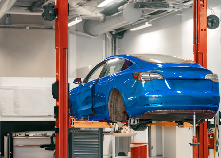 Electric car getting repaired on a vehicle lift