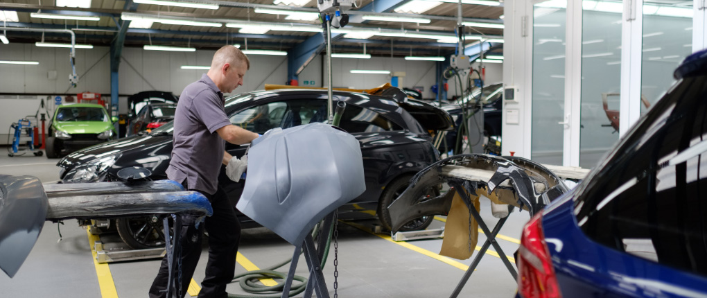 Man working on repairing bumper of car